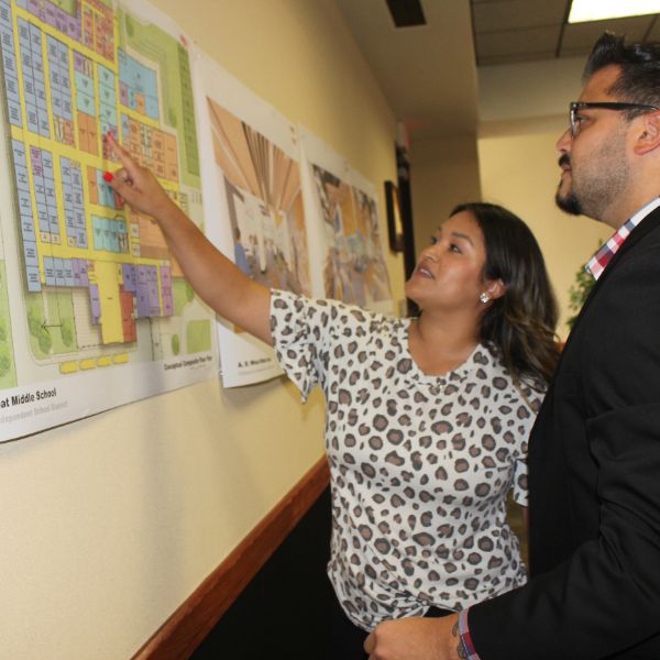  two people looking at a building plan